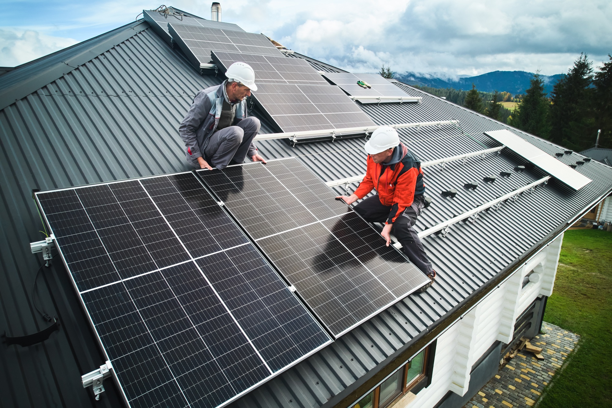 Men workers installing solar panels on roof of house in nova scotia