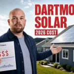 Presenter holding a power bill beside a Dartmouth home with rooftop solar panels for a 2026 solar cost guide